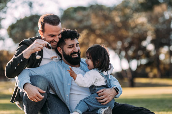 Gay family play with their daughter in the park